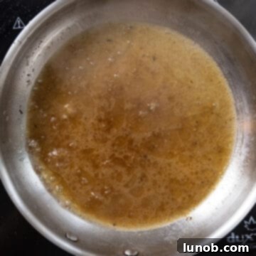 The Art of Perfect Carbonara 7 A quarter cup of starchy pasta water added to the guanciale fat in the saucepan, ready to emulsify.