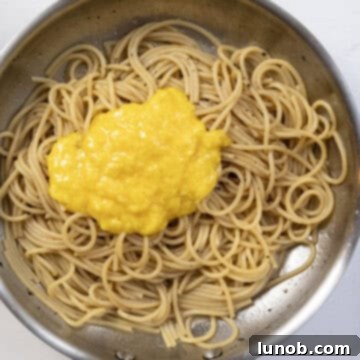 The Art of Perfect Carbonara 9 Egg and cheese mixture being rapidly stirred into the hot pasta in the pan, off the heat.