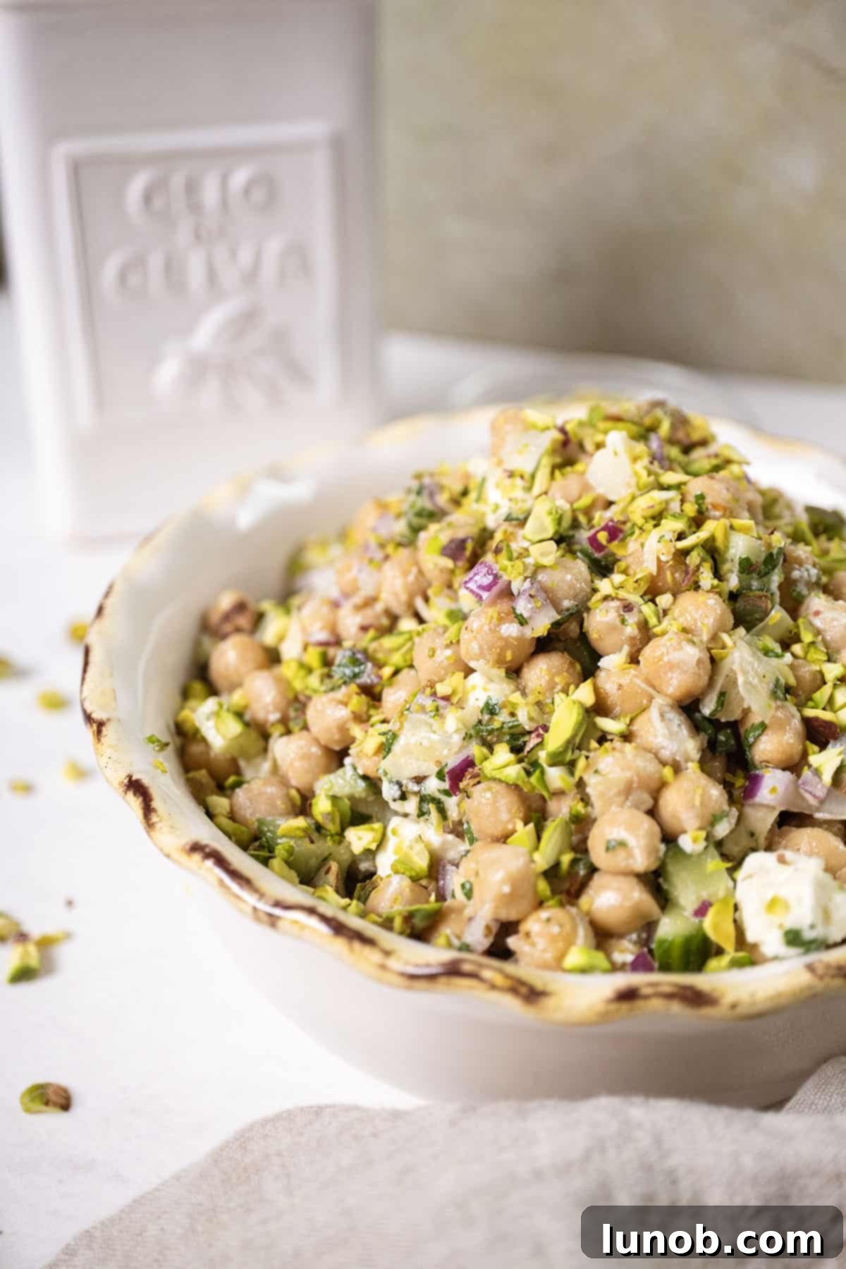 Chickpea and feta salad in a bowl topped with pistachios
