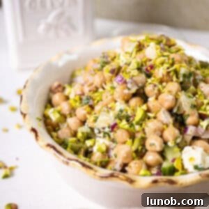 Chickpea and feta salad in a bowl topped with pistachios