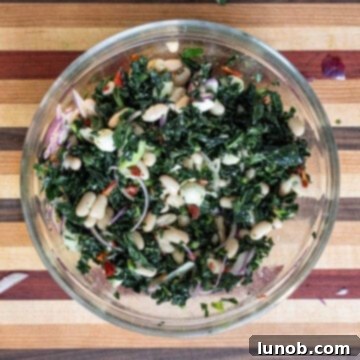 The vibrant kale and cannellini bean salad after being mixed with a lemon basil vinaigrette, ready for chilling.