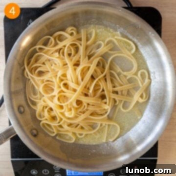 Traditional Roman Fettuccine Alfredo 7 Adding cooked al dente pasta to the butter and pasta water mixture, tossing to coat.