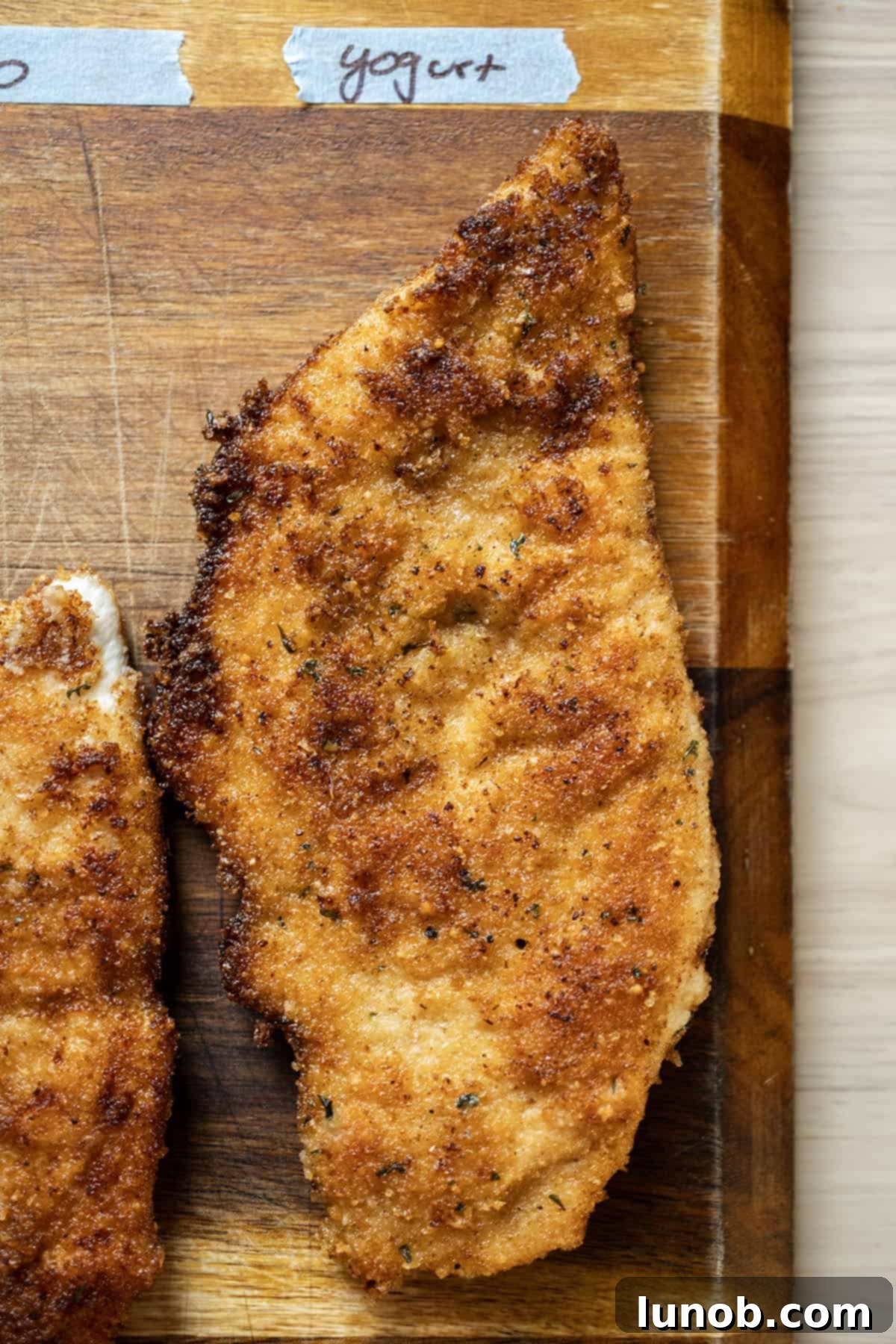 Chicken cutlet fried to a golden crisp, indicating it was battered in yogurt, showing some areas where the breading may have come off.