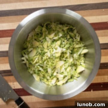Crispy Pancetta Brussels Sprout Salad 7 Thinly shredded Brussels sprouts in a large mixing bowl, ready for other ingredients.
