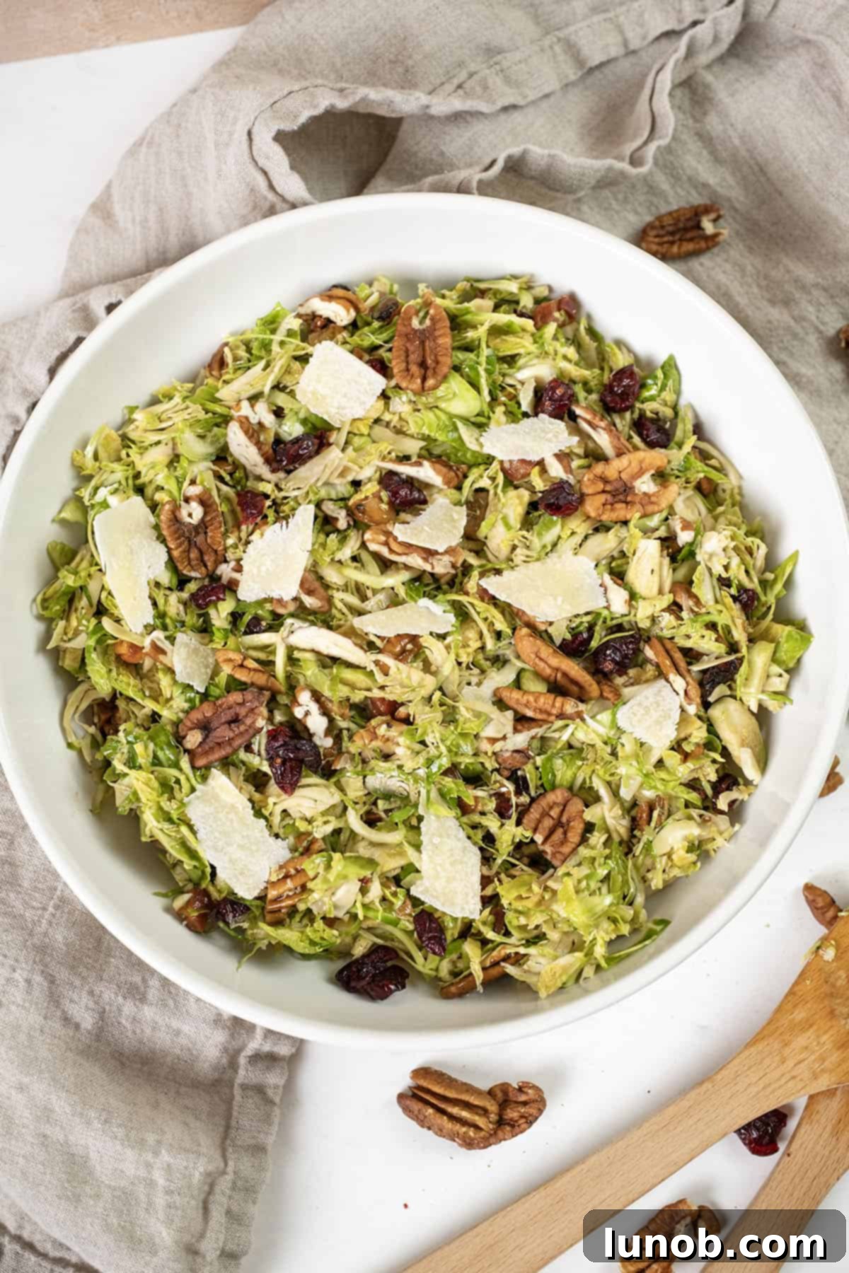 Crispy Pancetta Brussels Sprout Salad 10 Beautifully presented Brussels sprouts salad in a serving bowl, garnished with dried cranberries and pecans.