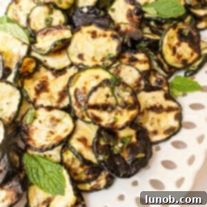 Minty Marinated Zucchini 10 Zucchini alla scapece on a tray garnished with mint.