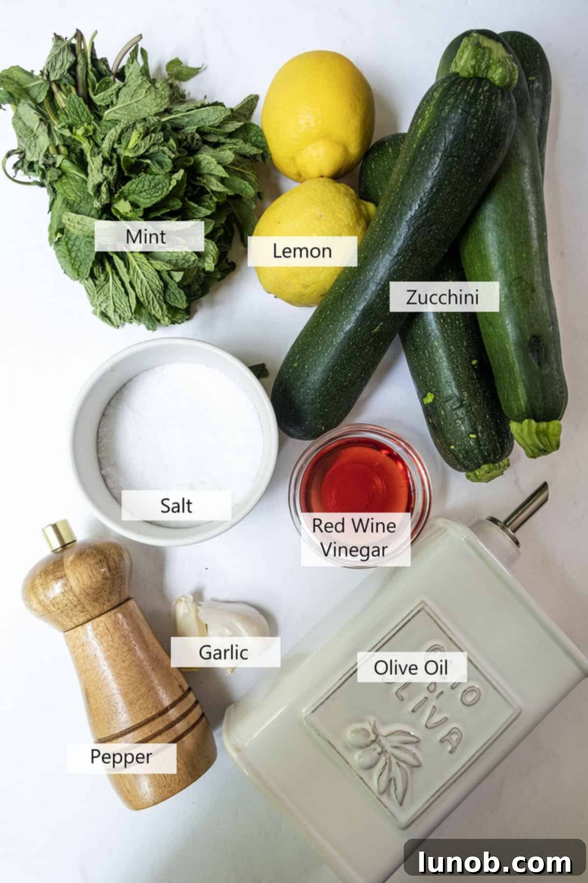 Minty Marinated Zucchini 3 Fresh ingredients laid out for Zucchini alla Scapece, including zucchini, mint, olive oil, and vinegar.