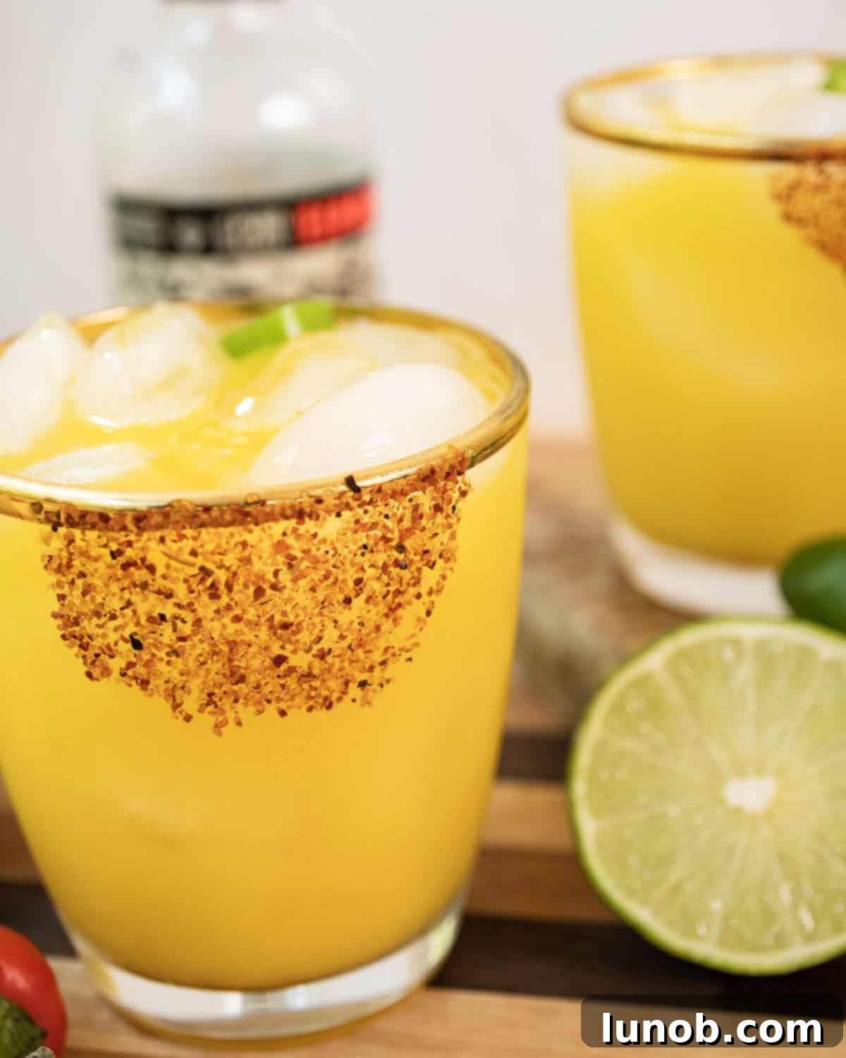 Sizzling Mango Margarita 5 A finished spicy mango margarita, garnished with lime and surrounded by more fresh limes and jalapenos.