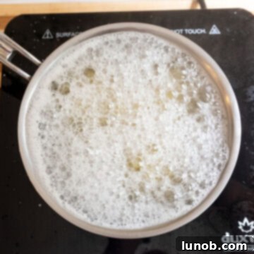Vibrant Orzo and Chickpea Salad 4 Boiling orzo pasta in a pot of water.