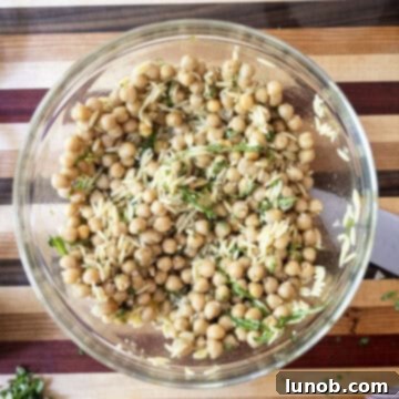 Vibrant Orzo and Chickpea Salad 7 Combining garbanzo beans, orzo, basil, and dressing in a large mixing bowl.
