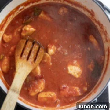 Fiery Chicken Rigatoni 11 Seared chicken pieces simmering gently in the vibrant tomato sauce in the saucepan.