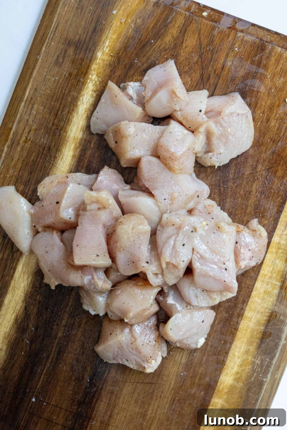 Fiery Chicken Rigatoni 4 Close-up of chicken breast chopped into 1½-inch pieces and seasoned in a bowl, ready for searing.