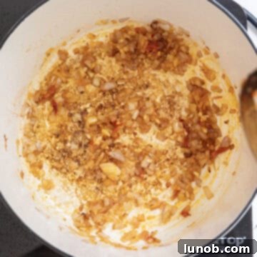 Fiery Chicken Rigatoni 8 Sautéed shallots, minced garlic, and Calabrian chili peppers mixed together in a saucepan, releasing fragrant aromas.