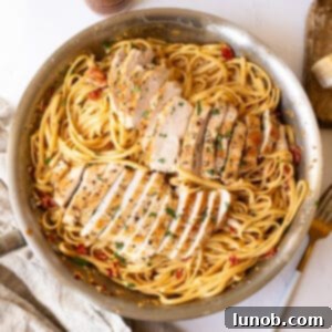 Creamy pasta in a pan topped with golden brown chicken.