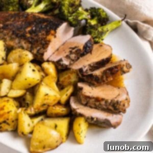 Rustic Italian Cast Iron Pork Tenderloin 11 Sliced pork tenderloin served on a plate with roasted potatoes and broccoli.