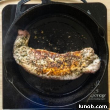 Rustic Italian Cast Iron Pork Tenderloin 6 Pork tenderloin flipped, searing on the other side in the cast iron pan.
