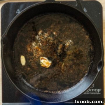 Rustic Italian Cast Iron Pork Tenderloin 9 White wine butter sauce simmering and reducing in the cast iron pan.