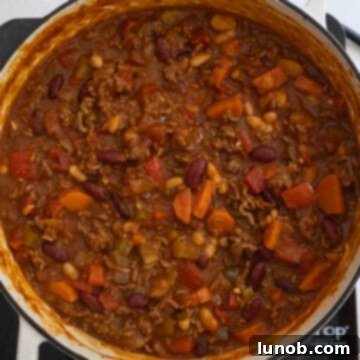 Golden Harvest White Bean Chili 11 The white bean pumpkin chili gently simmering in the Dutch oven, steam rising, as flavors meld and deepen.
