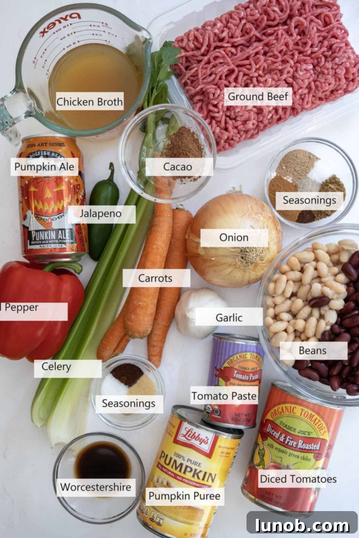 Golden Harvest White Bean Chili 3 A vibrant selection of fresh ingredients and spices laid out on a wooden surface, ready for making pumpkin chili.