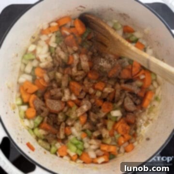 Golden Harvest White Bean Chili 6 A mix of aromatic spices being stirred into softened vegetables in a Dutch oven, infusing deep flavor.