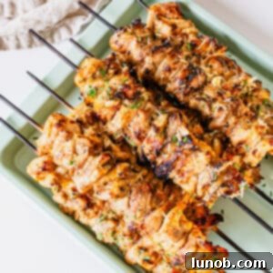 Savory Garlic Parmesan Chicken Skewers 12 Garlic parm chicken skewers on a baking pan.