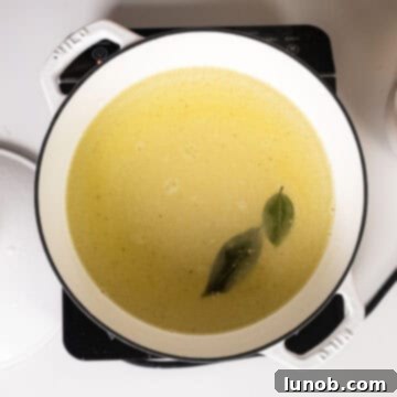 Velvety Golden Polenta 4 Whisking together cold water, olive oil, salt, bay leaves, and polenta.