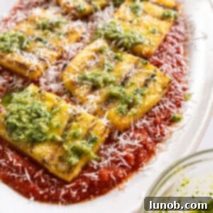 Grilled polenta on marinara topped with pesto and parmigiano.