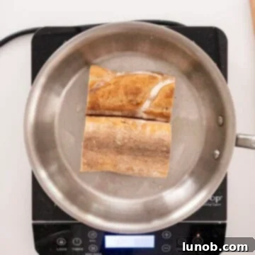 Bread slices being toasted in butter in a pan, creating a golden-brown crust.