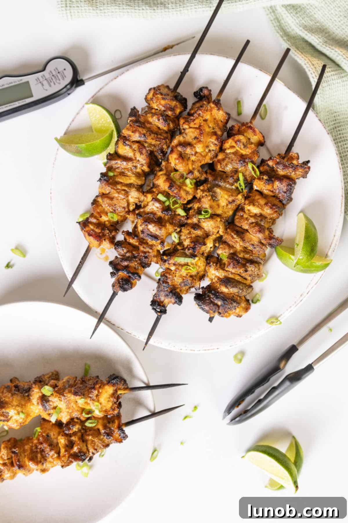 Dynamite Chicken Skewers 2 Grilled Bang Bang Chicken Skewers with fresh lime wedges, showcasing their crispy, caramelized texture.