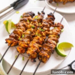 Dynamite Chicken Skewers 13 Bang Bang Chicken skewers with limes on the side.