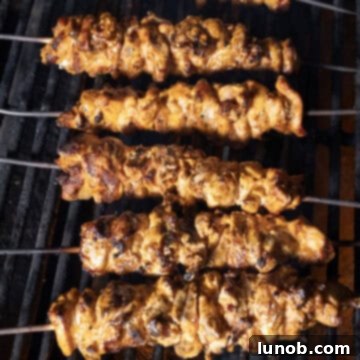Dynamite Chicken Skewers 10 Crispy, perfectly cooked chicken skewers on the grill, showing delicious char marks.