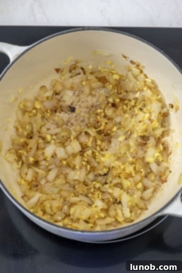 Sweet and Zesty Roasted Carrot Ginger Soup 6 sauteing onions with garlic and ginger in a dutch oven