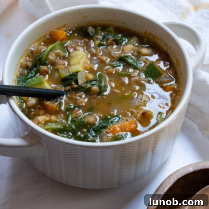 Bright and lemony white bean and lentil soup in a ceramic bowl.