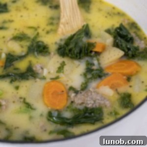 A serving of creamy Zuppa Toscana soup in a bowl with sausage, kale, and potatoes.