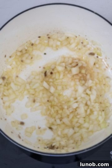 Chopped onions gently sautéing in a Dutch oven with residual sausage fat.