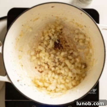 Ultimate One-Pot Lasagna Soup 6 Finely chopped onions sautéing in olive oil in the Dutch oven until softened and translucent, ready for garlic.