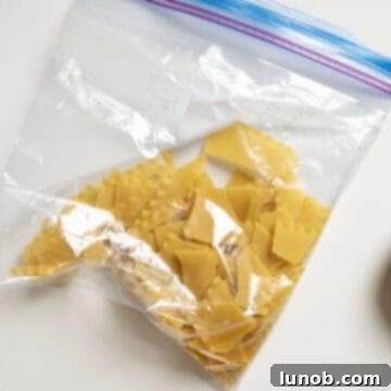 Ultimate One-Pot Lasagna Soup 10 Dried lasagna noodles broken into irregular, bite-sized pieces inside a plastic bag, ready to be added to the soup.