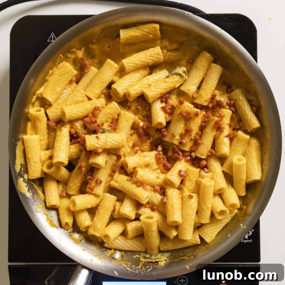 Velvety Pumpkin Pasta 11 A large pan of creamy pumpkin pasta, tossed with crispy pancetta and ready to be served.