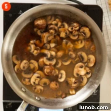Classic Veal Marsala 8 Mushrooms simmering in marsala wine and broth in a pan.