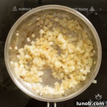 Close-up of golden-brown sautéed onions in a pan, removed from heat and cooling.