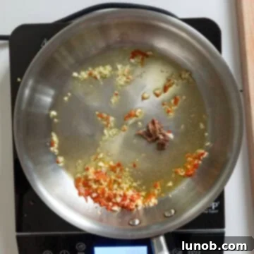 Ebony Ocean Pasta with Seared Calamari 5 Garlic, red chili pepper, and anchovies sizzling in olive oil in a saucepan.