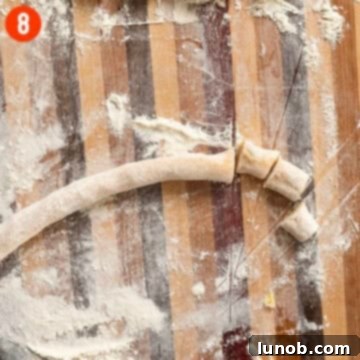 A long, thin rope of gnocchi dough, perfectly rolled and ready to be cut.