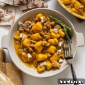 Pumpkin Gnocchi Perfection 12 Gnocchi with pumpkin sauce and sausage, presented in a bowl.