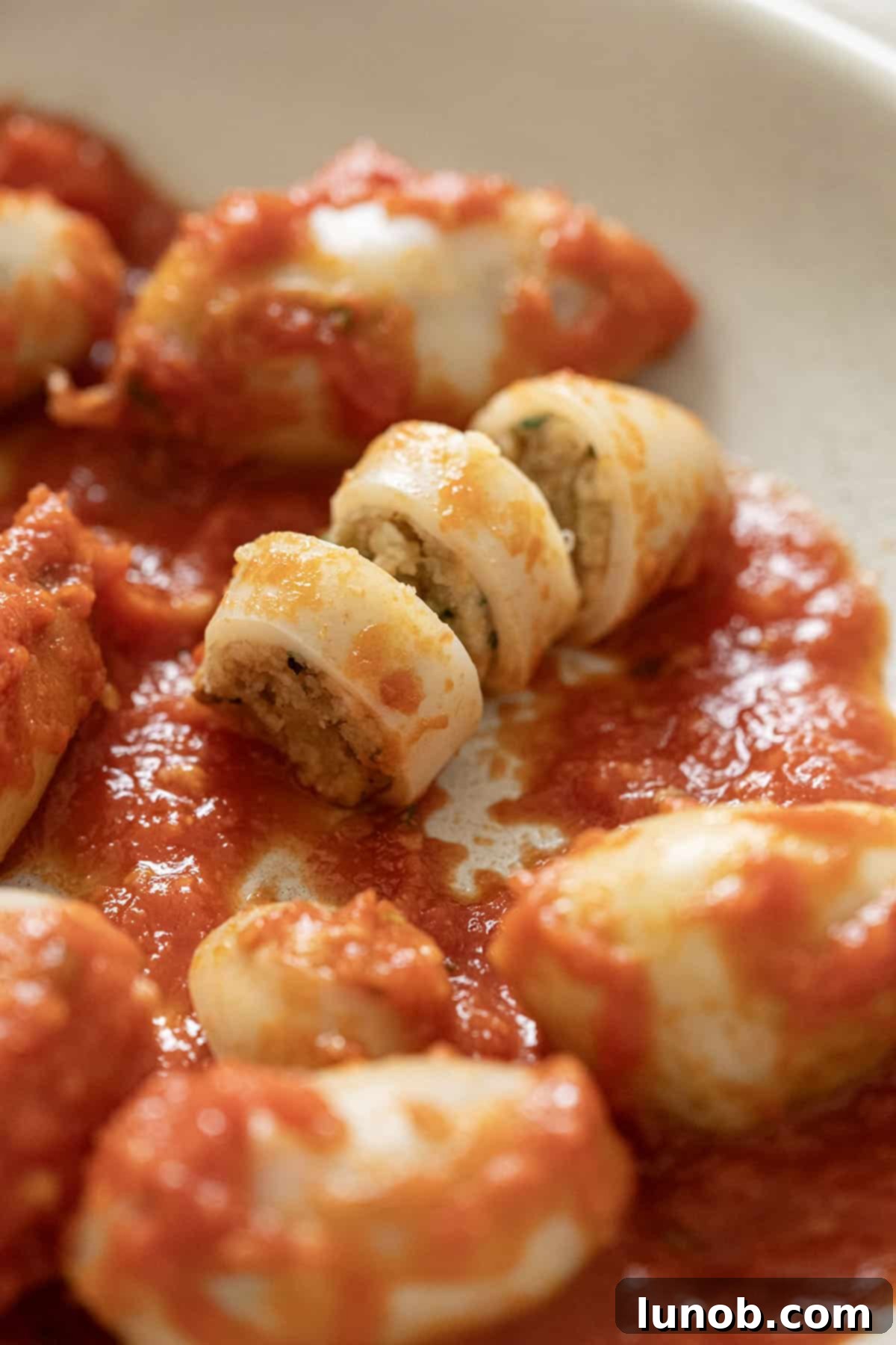 Savory Stuffed Squid 2 Sliced open stuffed calamari on a plate.