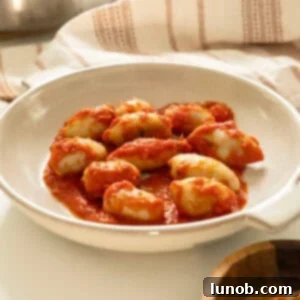 Savory Stuffed Squid 11 Stuffed calamari in tomato sauce on a plate.