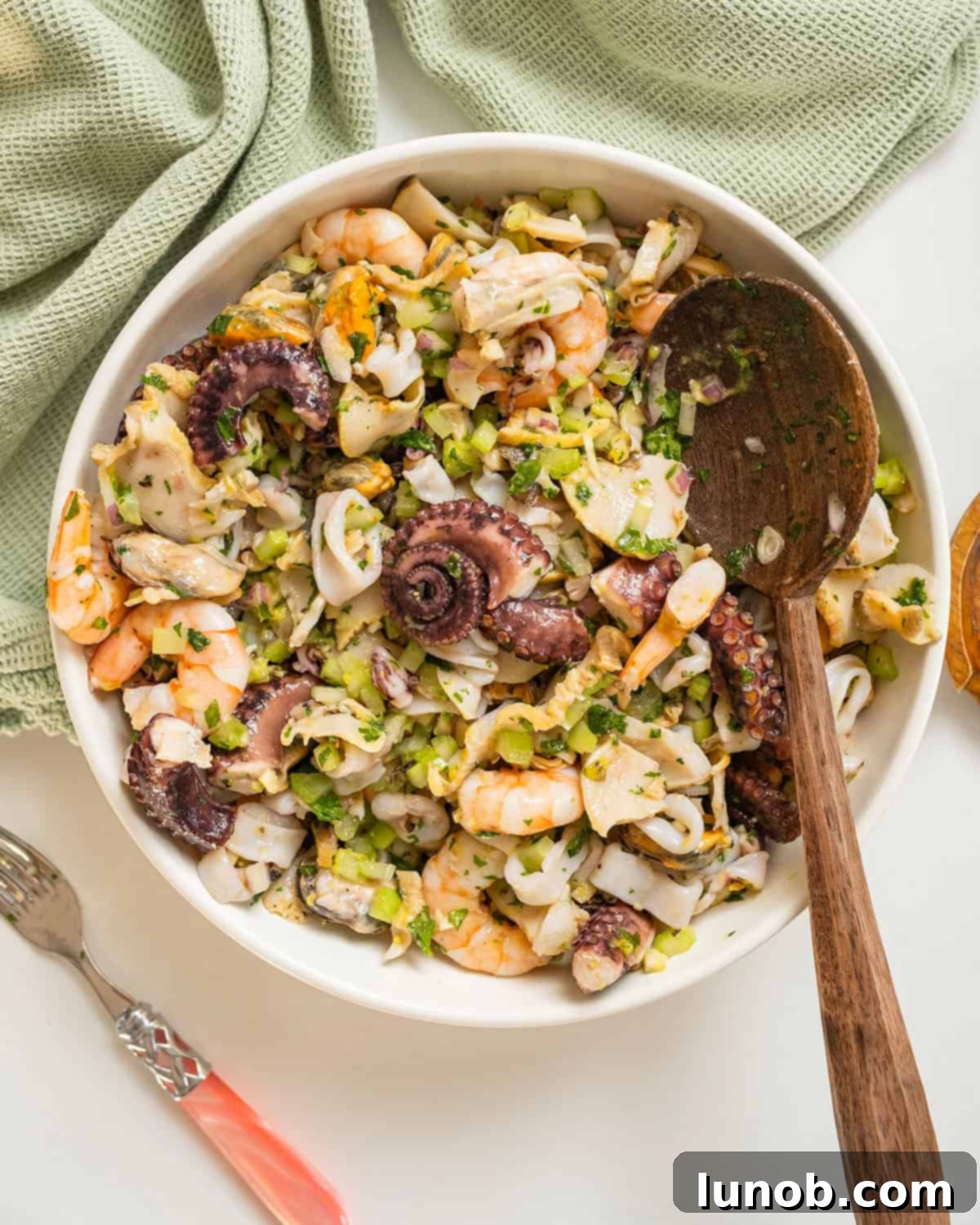 A vibrant Italian Seafood Salad (Insalata di Mare) ready to be served, showcasing a mix of cooked seafood such as calamari, shrimp, mussels, and octopus, tossed with fresh herbs and vegetables in a light dressing.