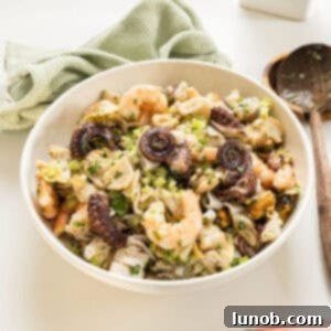 A large bowl of freshly prepared Italian Seafood Salad, garnished with fresh parsley, ready to be served.