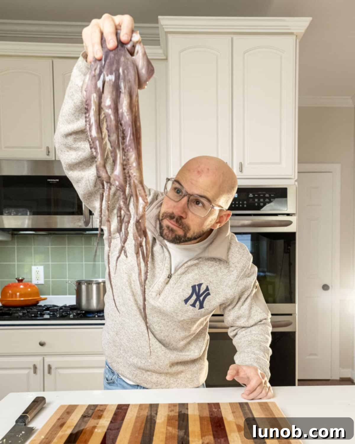 The author holding a raw octopus, emphasizing the freshness and hands-on tradition of Italian cooking.