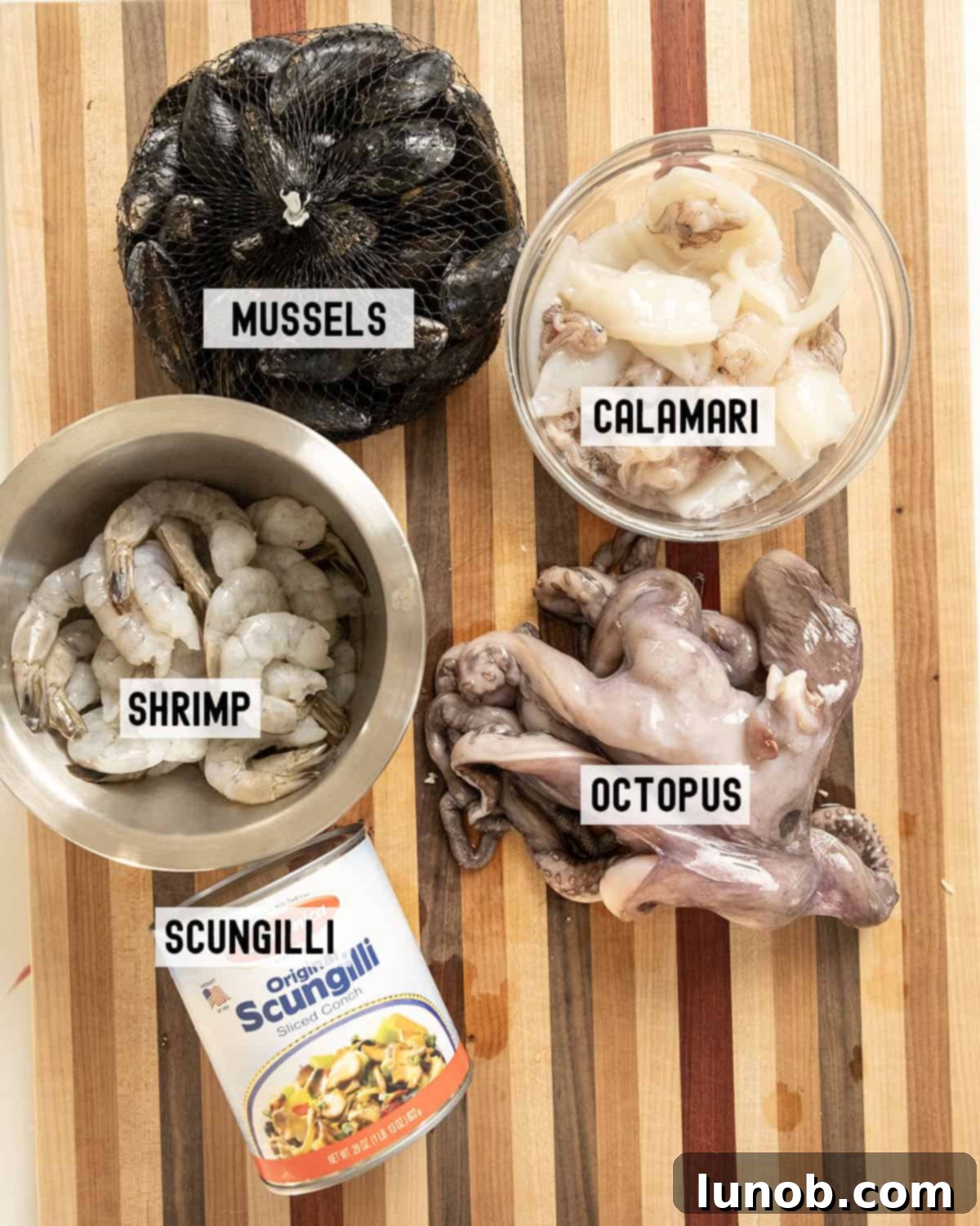 A selection of fresh seafood ingredients, including mussels, shrimp, octopus, and calamari, laid out for preparing Italian Seafood Salad.