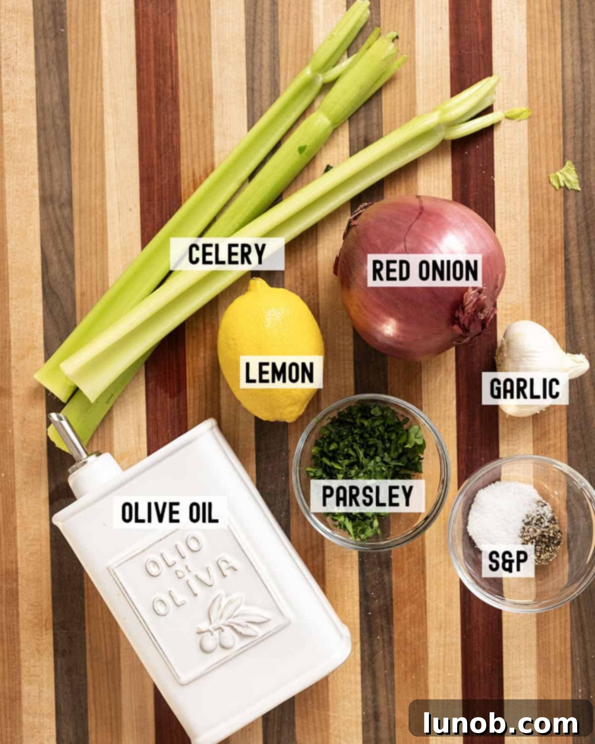 Fresh aromatic ingredients including red onion, celery, garlic, lemons, and a bottle of olive oil, essential for dressing the Italian Seafood Salad.